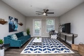 Located in Sandy Springs, GA, this single-floor residence offers a thoughtfully designed layout with a cohesive blend of modern finishes and comfortable living spaces. The open-concept living and dining area serves as the heart of the home, featuring warm wood-look flooring, a pendant light over the dining space, and a seamless view into the kitchen. The galley-style kitchen is well-equipped with white cabinetry, subway tile backsplash, stainless steel appliances, and granite-style countertops, with direct access to a laundry area. The dining area comfortably accommodates a round table and chairs beneath a stylish hanging light fixture. The bedrooms are carpeted for comfort, with large windows allowing natural light and outdoor views. The primary bedroom includes a ceiling fan and an en-suite bathroom featuring wood-look tile flooring, a vanity with granite-style counters, and a shower-tub combination. A secondary bedroom offers flexibility as a home office or guest room, also with a bright window. Additional spaces include a versatile flex room with decorative shelving, a hallway bathroom with a tub-shower combo, and ample closet storage throughout. The neutral color palette and updated finishes create a clean, modern ambiance throughout the home.
