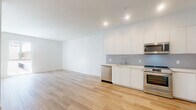Located on the iconic Wilshire Boulevard in the heart of Los Angeles, this thoughtfully designed one-bedroom, one-bathroom residence offers a clean, modern aesthetic across a well-utilized single floor. Light wood-look flooring flows seamlessly throughout the space, complementing the crisp white walls and creating a bright, cohesive atmosphere.

The open-plan kitchen and living area forms the heart of the home. The kitchen is outfitted with sleek, flat-front white cabinetry, light quartz countertops, a textured tile backsplash, and a full suite of stainless steel appliances including a range, over-the-range microwave, dishwasher, and refrigerator. The living area benefits from large windows that invite natural light and offer views of the surrounding Los Angeles cityscape.

The bedroom is a calm, sunlit retreat with large windows and clean white walls, allowing for flexible furniture arrangement. An adjacent dedicated closet features built-in shelving and dual hanging rods, providing well-organized storage.

The bathroom is finished with floor-to-ceiling white subway tile in the tub-shower combination, neutral floor tile, and polished chrome fixtures, delivering a clean and functional design. The overall ambiance of the space is modern, minimal, and move-in ready.