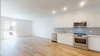 Located on the iconic Wilshire Boulevard in the heart of Los Angeles, this thoughtfully designed one-bedroom, one-bathroom residence offers a clean, modern aesthetic across a well-utilized single floor. Light wood-look flooring flows seamlessly throughout the space, complementing the crisp white walls and creating a bright, cohesive atmosphere.

The open-plan kitchen and living area forms the heart of the home. The kitchen is outfitted with sleek, flat-front white cabinetry, light quartz countertops, a textured tile backsplash, and a full suite of stainless steel appliances including a range, over-the-range microwave, dishwasher, and refrigerator. The living area benefits from large windows that invite natural light and offer views of the surrounding Los Angeles cityscape.

The bedroom is a calm, sunlit retreat with large windows and clean white walls, allowing for flexible furniture arrangement. An adjacent dedicated closet features built-in shelving and dual hanging rods, providing well-organized storage.

The bathroom is finished with floor-to-ceiling white subway tile in the tub-shower combination, neutral floor tile, and polished chrome fixtures, delivering a clean and functional design. The overall ambiance of the space is modern, minimal, and move-in ready.
