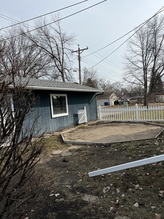 Side yard with fire pit area, secluded by house garage bushes - 2702 2nd St N
