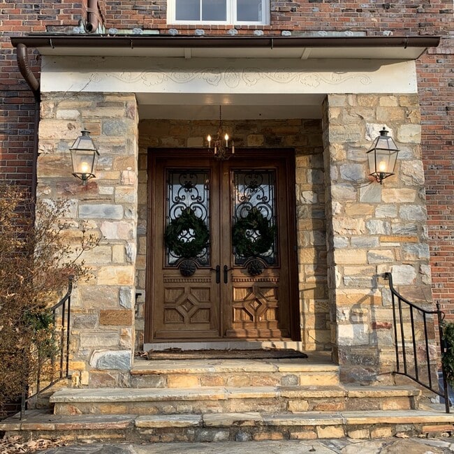 Front stone portico with custom wrought iron doors - 5553 Little Falls Rd