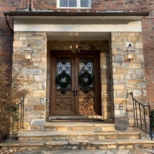 Front stone portico with custom wrought iron doors - 5553 Little Falls Rd