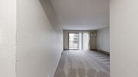 This two-bedroom, one-bathroom residence in Mound, Minnesota offers a practical and comfortable single-floor layout. The living room is a generous, open space finished with plush carpet and features sliding glass doors that open to a private balcony, allowing natural light to fill the room and providing views of the surrounding area. A wall-mounted air conditioning unit and baseboard heating ensure year-round comfort.

The kitchen has been thoughtfully updated with gray shaker-style cabinetry, white quartz countertops, a tile mosaic backsplash, stainless steel appliances including a gas range and refrigerator, and durable wood-look vinyl plank flooring — giving it a modern, functional feel.

The primary bedroom is a well-proportioned retreat with carpet flooring, a ceiling fan with light fixture, a window with vertical blinds, and a sliding-door closet with built-in shelving. The second bedroom also features carpet, a ceiling fan, closet access, and a window for natural light. In total, four closets are distributed throughout the unit, providing excellent storage capacity.

The bathroom is clean and bright, featuring a white tub-shower combo, a vanity with a white countertop, dark hardware accents, and classic mosaic tile flooring. A hallway connects the main areas of the home seamlessly.