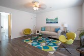 Located at 100 Pleasant Court in Newport News, Virginia, this two-floor home offers a well-designed layout with functional living spaces across both levels. The living room serves as a welcoming gathering area, featuring durable hardwood-style flooring, a ceiling fan, and large windows fitted with blinds that allow generous natural light to fill the room. The kitchen is outfitted with white cabinetry, granite-style countertops, white appliances including a gas range, dishwasher, and built-in microwave, alongside a large window that brightens the space. The bedrooms are comfortable and well-proportioned, each featuring warm hardwood flooring, ceiling fans, and windows that provide natural light and outdoor views. One additional room offers flexible use as a playroom, home office, or extra bedroom, also finished with hardwood flooring and a ceiling fan. The bathrooms are clean and functional, with one featuring a tiled tub-shower combination and wood-style flooring, and another presented as a half bath. Throughout the home, a consistent neutral color palette and hardwood-style floors create a cohesive and inviting atmosphere suitable for a variety of lifestyles.