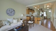 Located at 5199 Edwards Farms Rd in Hilliard, Ohio, this two-floor residence offers a comfortable and well-appointed living environment with a cohesive, warm aesthetic throughout. The main level showcases an open-concept design that seamlessly connects the living room, kitchen, and dining area, creating a functional and inviting flow. The living area is finished with plush carpeting and soft, neutral wall tones that lend a welcoming ambiance, complemented by a textured ceiling that adds subtle character to the space. The kitchen is equipped with warm honey-toned wood cabinetry, dark countertops, and full appliances including a refrigerator, range, and microwave. A peninsula counter with bar-height seating bridges the kitchen and dining area, making it ideal for casual meals or entertaining. The dining space is accented by a decorative pendant chandelier, adding a touch of elegance. Large windows allow natural light to filter into the space, enhancing the bright and airy feel. The thoughtful layout across two floors provides distinct areas for living and privacy, making this residence a practical and charming home in the Hilliard community.
