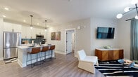 Located at 120 Matheson Ave in Charlotte, NC, this well-appointed 2-bedroom, 2-bathroom residence offers a thoughtfully designed single-floor layout that balances modern style with practical comfort. Wide-plank wood-look flooring flows throughout, creating a cohesive and warm aesthetic.

The open-concept kitchen and living area serve as the heart of the home. The kitchen features crisp white shaker cabinetry with matte black hardware, stainless steel appliances including a French door refrigerator and range, and a striking teal tile backsplash. A peninsula with bar seating and pendant lighting makes it ideal for entertaining. The adjacent living room is bright and inviting, with natural light streaming through large windows.

A hallway with a modern globe chandelier connects the living areas to the private bedrooms. The spacious primary bedroom includes a ceiling fan, natural light from a large window, and access to a well-sized walk-in closet with wire shelving. The second bedroom offers a bold accent wall and ample natural light. Both bathrooms are finished with white vanities, matte black fixtures, and tub-shower combinations featuring marble-style surrounds.

Two dedicated closets provide generous storage throughout. The overall design is clean, contemporary, and move-in ready.