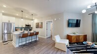Located at 120 Matheson Ave in Charlotte, NC, this well-appointed 2-bedroom, 2-bathroom residence offers a thoughtfully designed single-floor layout that balances modern style with practical comfort. Wide-plank wood-look flooring flows throughout, creating a cohesive and warm aesthetic.

The open-concept kitchen and living area serve as the heart of the home. The kitchen features crisp white shaker cabinetry with matte black hardware, stainless steel appliances including a French door refrigerator and range, and a striking teal tile backsplash. A peninsula with bar seating and pendant lighting makes it ideal for entertaining. The adjacent living room is bright and inviting, with natural light streaming through large windows.

A hallway with a modern globe chandelier connects the living areas to the private bedrooms. The spacious primary bedroom includes a ceiling fan, natural light from a large window, and access to a well-sized walk-in closet with wire shelving. The second bedroom offers a bold accent wall and ample natural light. Both bathrooms are finished with white vanities, matte black fixtures, and tub-shower combinations featuring marble-style surrounds.

Two dedicated closets provide generous storage throughout. The overall design is clean, contemporary, and move-in ready.