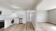 Located at 1110 S Wells St in Lake Geneva, Wisconsin, this 2-bedroom, 1-bathroom residence offers a well-organized single-floor layout designed for comfortable everyday living. The interior features a neutral, contemporary color palette with light gray walls and warm-toned luxury vinyl plank flooring throughout the main living and kitchen areas.

The kitchen is a standout feature, showcasing white shaker-style cabinetry, granite-look countertops, stainless steel appliances including a refrigerator, electric range, and microwave, as well as a dishwasher and an in-unit washer. A pendant light adds a decorative touch above the sink area.

The living room receives natural light through a sliding glass door that opens to an outdoor view, and is equipped with a ceiling fan. The primary bedroom is a comfortable size and includes a closet, while the second bedroom features light luxury vinyl plank flooring, a bright window with natural light, and baseboard heating. Both bedrooms are finished in soft neutral tones.

The bathroom is clean and functional, featuring a full tub-shower surround with built-in shelving, wood-look flooring, and white fixtures. Throughout the home, baseboard heating, ample closet space, and a cohesive modern aesthetic make this residence a practical and inviting option in Lake Geneva.