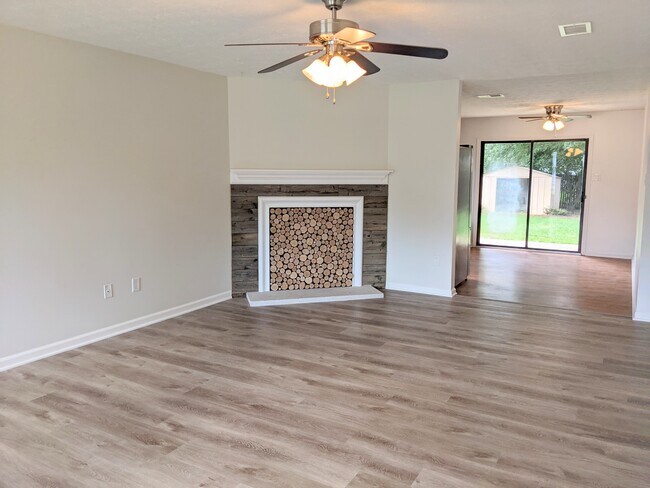 Living room with fireplace art-piece focal point, space continuous with kitchen. - 1649 Summerhill Dr