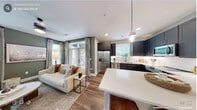 This thoughtfully designed 1-bedroom, 1-bathroom residence offers a cohesive open-concept layout that maximizes every square foot. The combined kitchen and living area serves as the heart of the home, where rich hardwood-style flooring flows seamlessly throughout. The kitchen is outfitted with dark slate-toned shaker cabinets, white quartz countertops, a subway tile backsplash, stainless steel appliances, and a peninsula island with pendant lighting and bar seating — ideal for casual dining or entertaining. The living room benefits from multiple windows dressed with floor-length curtains, filling the space with natural light, while a sage green accent wall adds depth and a calming, contemporary feel. The bedroom continues the refined color palette with a matching accent wall, large windows with outdoor views, and direct access to a well-organized closet. A dedicated bathroom completes the layout. Neutral gray tones and clean white trim are consistent throughout, creating a cohesive and polished aesthetic. The thoughtful use of space, quality finishes, and abundant natural light make this residence both functional and visually inviting.
