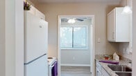 This 2-bedroom, 1-bathroom home at 108 London Ct in Fayetteville, NC offers a well-organized single-floor layout with a functional and comfortable living environment. The kitchen is a standout feature, equipped with granite countertops, a double undermount stainless steel sink, white cabinetry, and a window with natural light overlooking the outdoors. A ceiling fan with a light fixture and adjacent access to the living area makes the kitchen feel open and connected. The spacious living area features light hardwood-style flooring, neutral-toned walls, a ceiling fan, and a window that allows ample natural light. Both bedrooms are carpeted and finished in soft neutral tones, each with windows fitted with blinds. The generously sized primary bedroom includes a walk-in closet outfitted with wire shelving and hanging rods for ample storage. The bathroom is neatly appointed with a white vanity, mirror, and a tub/shower combination. A hallway connects the main living spaces efficiently. Throughout the home, consistent neutral paint tones, white trim, and carpet in the bedrooms create a clean and cohesive aesthetic suited for comfortable everyday living.