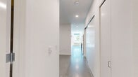 Located at 4225 SE Milwaukie Ave in Portland's vibrant Sellwood-Moreland neighborhood, this efficiently designed studio offers a thoughtfully laid-out single-floor plan with a living room and full bathroom. The living area is characterized by polished concrete floors, crisp white walls, and recessed lighting complemented by a ceiling fan, creating a bright and airy atmosphere. Large windows fitted with roller shades allow natural light to pour in, while a glass door provides direct access to a private outdoor area featuring a metal railing, young trees, and a cedar privacy fence — offering a refreshing outdoor retreat. A wall-mounted HVAC unit ensures year-round climate control. The bathroom continues the modern aesthetic with clean white cabinetry, a streamlined vanity with a light countertop, matte black hardware accents, and polished concrete flooring that ties the space together cohesively. The overall design emphasizes minimalism and functionality, making excellent use of every square foot. The neutral palette and contemporary finishes throughout create a versatile canvas well-suited to a variety of living arrangements.