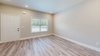 Located at 2815 Trenton Rd in Clarksville, TN, this two-story home offers 4 bedrooms and 3 bathrooms across two well-proportioned floors. The main level features an open kitchen and living area with light-toned luxury vinyl plank flooring, recessed lighting, and a clean, modern aesthetic. The kitchen is equipped with white shaker-style cabinetry, stainless steel appliances including a side-by-side refrigerator, electric range, built-in microwave, and dishwasher, all accented by pendant lighting and ample counter space. A carpeted staircase with a warm wood handrail connects the two floors. The bedrooms are finished with soft wall-to-wall carpeting, ceiling fans, and windows that allow natural light and outdoor views. The primary bedroom includes a spacious walk-in closet outfitted with wire shelving and hanging rods. The bathrooms are finished in a consistent neutral palette, featuring white tub-shower combinations, dark oil-rubbed bronze fixtures, LVP flooring, and white vanities. Hallways are bright and open, with panel-style doors and recessed lighting throughout. A utility room and additional closets provide practical storage. The overall interior presents a cohesive, move-in-ready design with neutral tones and contemporary finishes.
