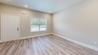 Located at 2815 Trenton Rd in Clarksville, TN, this two-story home offers 4 bedrooms and 3 bathrooms across two well-proportioned floors. The main level features an open kitchen and living area with light-toned luxury vinyl plank flooring, recessed lighting, and a clean, modern aesthetic. The kitchen is equipped with white shaker-style cabinetry, stainless steel appliances including a side-by-side refrigerator, electric range, built-in microwave, and dishwasher, all accented by pendant lighting and ample counter space. A carpeted staircase with a warm wood handrail connects the two floors. The bedrooms are finished with soft wall-to-wall carpeting, ceiling fans, and windows that allow natural light and outdoor views. The primary bedroom includes a spacious walk-in closet outfitted with wire shelving and hanging rods. The bathrooms are finished in a consistent neutral palette, featuring white tub-shower combinations, dark oil-rubbed bronze fixtures, LVP flooring, and white vanities. Hallways are bright and open, with panel-style doors and recessed lighting throughout. A utility room and additional closets provide practical storage. The overall interior presents a cohesive, move-in-ready design with neutral tones and contemporary finishes.