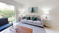 This single-floor residence offers a thoughtfully organized layout with a clean, bright aesthetic carried throughout. Large-format white tile flooring runs through the main living areas, hallways, and wet zones, creating a cohesive and easy-to-maintain foundation. The living room is light-filled and inviting, benefiting from a sliding glass door that opens to a greenery-lined outdoor area, allowing natural light to pour in and providing a seamless indoor-outdoor connection. A ceiling fan adds to the comfort of the space.

The kitchen is efficiently designed in a U-shaped configuration, featuring cream cabinetry, white countertops, a stainless steel range, and an under-cabinet ventilation hood. Adjacent to the kitchen, a dedicated laundry area houses a full-sized top-load washer and dryer set, framed by louvered bifold doors for convenient concealment.

The residence includes multiple bedrooms. The primary bedroom features tile flooring and a window with garden views, while a secondary bedroom maintains a similarly bright and airy feel with natural light filtering through vertical blinds. A third bedroom offers a versatile, smaller footprint suited for a child's room or home office. The bathroom provides a full tub-shower combination with tile surround and large-format floor tile throughout.