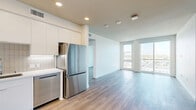 Located on El Cajon Boulevard in San Diego's North Park neighborhood, this modern 2-bedroom, 2-bathroom residence offers a thoughtfully designed open-concept layout with contemporary finishes throughout. Light wood-style flooring runs throughout the unit, complementing the clean white walls and recessed lighting that create a bright, cohesive aesthetic.

The kitchen, dining, and living areas flow seamlessly together, forming a versatile shared space ideal for everyday living and entertaining. The kitchen is well-appointed with sleek white flat-panel cabinetry extending to the ceiling, white tile backsplash, light quartz countertops, and a full suite of stainless steel appliances including a gas range, dishwasher, French door refrigerator, and microwave.

Both bedrooms are generously proportioned, featuring large windows and sliding glass doors that frame expansive views of the San Diego cityscape and surrounding neighborhood. Each bedroom benefits from abundant natural light and direct outdoor access. Dedicated walk-in closets with built-in shelving and hanging rods offer ample storage.

The bathrooms are finished in a clean, modern style, with one featuring a glass-enclosed walk-in shower with tiled surround. Additional highlights include in-unit laundry and a hallway connecting all rooms for an efficient, well-organized floor plan.