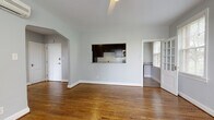 Located at 200 Rhode Island Avenue NE in Washington, DC, this single-floor unit offers a thoughtfully designed layout with a seamless flow between living spaces. Rich hardwood flooring runs throughout the main areas, complemented by soft gray walls and crisp white trim that give the interior a clean, modern aesthetic.

The spacious living area is anchored by elegant arched doorways that lend a classic architectural character to the space. A pass-through window connects the living area directly to the kitchen, enhancing the open feel. The kitchen is outfitted with dark espresso cabinetry, granite countertops, a white subway tile backsplash, and stainless steel appliances, including a range, microwave, and refrigerator. An in-unit washer is also conveniently located within the kitchen.

A sunlit room adjacent to the main living space features large French-style windows with views of surrounding greenery, a ceiling fan, and gleaming hardwood floors — ideal as a sitting room or flex space. The bedrooms are generously sized, each benefiting from multiple windows with natural light and hardwood floors. The bathroom includes white cabinetry, a dark granite vanity countertop, a large mirror, and tiled flooring, with an adjacent walk-in closet offering built-in shelving for ample storage.