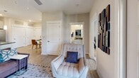 Located at 4212 Napa Oak Dr in Charlotte, NC, this single-floor residence offers a thoughtfully designed layout with modern finishes throughout. The open-concept kitchen is a standout feature, showcasing granite countertops, a central island with bar seating, sleek gray cabinetry, stainless steel appliances, and pendant lighting that adds a contemporary touch. Adjacent to the kitchen, a dedicated dining nook provides an intimate space for meals, while the living room impresses with French doors that open to an outdoor balcony, flooding the space with natural light. Ceiling fans are present throughout, enhancing comfort and airflow. The bedrooms offer plush carpeting, large windows with outdoor views, and generous closet space. The primary bathroom features wood-look flooring, a granite-topped vanity with gray cabinetry, and a tub-shower combination, with direct access to a walk-in closet. A second full bathroom includes a clean, bright tub-shower setup. The residence flows cohesively with warm neutral tones and light wood-look flooring across the main living areas, creating a bright and welcoming ambiance throughout every room.