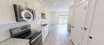 This contemporary 520 square foot apartment offers a thoughtful blend of comfort and style. The single-floor layout comprises one bedroom, measuring an impressive 250 square feet, a full bathroom, a functional kitchen, and a dedicated closet space. 

The interior boasts sleek, modern finishes throughout. Light-toned wood flooring extends across the entire apartment, creating a sense of warmth and continuity. The living area is adorned with a modern ceiling fan and benefits from ample natural light through large windows that lead to a private balcony, offering views of the surrounding area.

The kitchen is a highlight, featuring white cabinetry, granite countertops, and stainless steel appliances including a built-in microwave and full-sized refrigerator. A subway tile backsplash adds a touch of contemporary flair.

The bathroom showcases a glass-enclosed shower with white tiled walls, providing a clean and bright aesthetic. The bedroom, with its generous proportions, can comfortably accommodate a large bed and additional furniture.

Situated at 3806 University Dr in Durham, NC, this apartment is part of a larger complex that offers residents access to beautifully landscaped grounds. The exterior features a mix of modern architectural styles with grey and white siding. A community green space with seating areas and artistic installations provides a pleasant outdoor environment for relaxation and social gatherings.