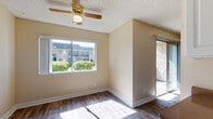 Located at 1125 N Broadway in Escondido, California, this single-floor unit offers a well-organized layout with a variety of functional living spaces. The entryway greets you with wood-style plank flooring that carries through much of the unit, providing a warm and cohesive aesthetic.

The living area is bright and inviting, featuring a ceiling fan with light fixture, a textured ceiling, and a large sliding glass door alongside a window that frames views of the surrounding landscaped greenery. Natural light fills the space throughout the day.

The galley-style kitchen is efficiently designed with white cabinetry, brown laminate countertops, a stainless steel sink, and matching white appliances including a refrigerator and range. The layout maximizes storage and workspace within a compact footprint.

The bedrooms are carpeted and well-proportioned, each offering windows with outdoor views and clean, neutral wall tones. The bathroom includes a single-sink vanity with white cabinetry and brown countertop, a combined tub and shower, a toilet, wood-style flooring, and a small window for natural ventilation.

Throughout the unit, consistent warm beige tones, white trim, and textured ceilings create a clean, uniform appearance suited to a range of living arrangements.