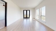 Located at 600 Winners Circle in Rowlett, TX, this contemporary single-floor residence offers three bedrooms, two bathrooms, and sweeping waterfront views throughout. The open-concept living, dining, and kitchen area serves as the heart of the home, with light wood-look flooring, crisp white walls, and abundant natural light pouring in through large windows and glass French doors. The kitchen is equipped with stainless steel appliances, warm wood cabinetry, a built-in wine rack, subway tile backsplash, and a spacious center island with a white quartz countertop, undermount sink, and stylish pendant lighting overhead. French doors open directly to one of two patios, framing breathtaking lake views. The generously sized primary bedroom features plush carpeting, a ceiling fan, and dual windows overlooking the water. Additional bedrooms are carpeted and well-lit, each with ceiling fans. The bathrooms offer wood-tone tile flooring, dual-sink vanities with black-framed mirrors, and a soaking tub. A dedicated laundry room with washer and dryer and a utility room add practical convenience. Throughout, the design balances modern aesthetics with a bright, airy ambiance accentuated by remarkable waterfront scenery.