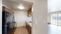 Located at 1001 Leland in Detroit, Michigan, this one-bedroom, one-bathroom unit offers a well-organized, single-level layout that makes efficient use of its space. Warm-toned hardwood-style flooring flows throughout the main living areas, creating a cohesive and clean aesthetic.

The galley-style kitchen is thoughtfully designed with rich dark-brown cabinetry on both sides, light-toned countertops, a stainless steel sink, and black appliances including an electric range and dishwasher. A wall-mounted intercom system is conveniently located at the kitchen entry. The adjacent living room is bright and airy, highlighted by a sliding glass door that opens to a private balcony, allowing generous natural light to fill the room.

The bedroom offers a comfortable, carpeted retreat with a large window fitted with vertical blinds that usher in natural light. A built-in closet with a six-panel door and shelving provides ample storage. The full bathroom features wood-style flooring, a tiled tub and shower combination, and a vanity with matching dark cabinetry. Neutral wall tones throughout the unit lend a clean, move-in-ready feel to this practical Detroit residence.