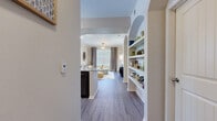This thoughtfully designed one-bedroom, one-bathroom residence offers a functional and stylish open-concept layout across a single floor. Wood-look plank flooring flows throughout, creating a cohesive aesthetic that connects each living area seamlessly.

The combined kitchen, dining, and living area serves as the heart of the home. The kitchen is equipped with dark espresso cabinetry, granite countertops, stainless steel appliances including a range, dishwasher, and microwave, plus a tile backsplash. A peninsula counter opens to the living space, ideal for casual dining. A dedicated dining nook with a glass-top table sits adjacent, bathed in natural light from a large window with blinds. The living room features crown molding, a ceiling fan, and generous natural light through wide windows with floor-length drapes.

A distinctive arched built-in shelving unit adds architectural character to the entryway hallway. The bedroom is a comfortable retreat with a ceiling fan, multiple windows, and a spacious walk-in closet complete with multi-tiered shelving and hanging rods. The bathroom features dual vanities with granite countertops and dark cabinetry, providing ample storage. The kitchen also includes louvered utility closet doors, adding practical storage to the space.