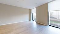 Located at 6445 America Blvd in Hyattsville, MD, this well-designed one-bedroom, one-bathroom unit offers a thoughtful layout across a single floor. The open-concept living, dining, and kitchen area serves as the heart of the home, featuring light hardwood flooring, recessed lighting, and neutral tones that create a clean, modern aesthetic. Floor-to-ceiling windows flood the living space with natural light and provide outdoor views, enhancing the sense of openness throughout.

The kitchen is outfitted with stainless steel appliances, including a refrigerator, range, and built-in microwave, complemented by white cabinetry, a sleek quartz countertop island with a built-in sink, and a subway tile backsplash. The island provides both prep space and casual dining functionality.

The bedroom features plush carpet flooring, neutral walls, and access to a large window with an exterior view, as well as closet storage. Three closets total are distributed throughout the unit, offering generous storage.

The bathroom is finished with large-format tile flooring, a white vanity with quartz countertop, an LED-backlit mirror, and a full tub-shower combo. A hallway connects the main living areas to the private bedroom and bathroom, maintaining a logical and efficient flow throughout the unit.