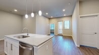Located at 600 E North Grove Blvd in Waxahachie, TX, this well-appointed 2-bedroom, 2-bathroom home offers a thoughtfully designed single-floor layout that balances modern style with everyday functionality. The open-concept kitchen, dining, and living area serves as the heart of the home, anchored by a large center island with granite countertops, an undermount sink, and elegant pendant lighting overhead. White shaker cabinetry, a decorative tile backsplash, and a full suite of stainless steel appliances — including a refrigerator, range, microwave, and dishwasher — complete the kitchen. Wood-look flooring runs consistently throughout the space, adding warmth and visual continuity. The living area opens to natural light through double doors and windows fitted with blinds. Both bedrooms are well-proportioned, bright, and serene, each featuring windows that invite natural light. The primary bathroom is finished with granite-topped white cabinetry, brushed nickel hardware, a large vanity mirror, and a glass-enclosed walk-in shower with tile surround. Two closets provide ample storage, and a dedicated hallway connects the spaces efficiently. The overall aesthetic is clean, contemporary, and move-in ready.