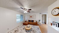 This well-appointed one-bedroom, one-bathroom unit in Austin, TX offers a thoughtfully designed layout across a single floor. The living room serves as the heart of the home, featuring warm hardwood-style flooring, a ceiling fan with light fixture, a textured ceiling, and a window with blinds that invites natural light into the space. The galley-style kitchen is efficiently arranged with gray shaker cabinetry, white countertops, a stainless steel sink, and stainless appliances including a refrigerator and range with hood — all complemented by a tile backsplash and wood-tone flooring. The generously sized bedroom provides a comfortable retreat with hardwood-style floors, a textured ceiling, and ample room for furnishings. A walk-in closet off the bedroom offers dual shelving on both sides, maximizing storage capacity. The full bathroom includes a tub-shower combination, toilet, and overhead cabinetry finished in matching gray shaker style consistent with the kitchen. A hallway connects the rooms efficiently, completing the functional floor plan. Throughout the unit, clean white walls and consistent flooring create a cohesive, move-in-ready aesthetic well-suited for Austin living.