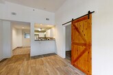 Located at 745 Hansell St SE in Atlanta's Grant Park neighborhood, this single-floor, three-bedroom, two-bathroom home offers a well-organized layout designed for comfortable everyday living. Wood-look flooring runs throughout the main living areas and bedrooms, lending a warm, cohesive aesthetic. A standout design element is the rustic sliding barn door, which adds a stylish contrast to the home's clean white walls and modern finishes.

The kitchen is well-appointed with white shaker cabinetry, dark granite countertops, a mosaic tile backsplash, and a full suite of stainless steel appliances, including a refrigerator, electric range, and over-the-range microwave. A pass-through opening connects the kitchen to the living area, enhancing the open feel of the space.

The bedrooms are bright and comfortable, with large grid-pane windows that bring in natural light and offer views of surrounding greenery. The primary bedroom is generously sized and includes a ceiling fan. The two bathrooms are tastefully finished with patterned tile surrounds — one featuring a tub-shower combination and the other a glass-enclosed walk-in shower. Additional highlights include two closets with wire shelving and a utility area with a water heater.