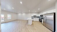 This contemporary 620 square foot apartment in Saint George, Utah, offers a thoughtfully designed living space. The open-concept layout seamlessly integrates the kitchen, living room, and dining area, creating a spacious feel. The kitchen boasts sleek white cabinetry, stainless steel appliances, and a stylish gray tile backsplash. A large quartz-topped island provides additional counter space and casual seating.

The bedroom, measuring 140 square feet, features a ceiling fan and a large window that floods the space with natural light. Throughout the apartment, light wood-look flooring adds warmth and complements the crisp white walls. The bathroom showcases a modern vanity with ample storage and a well-lit mirror.

Recessed lighting throughout enhances the contemporary ambiance, while strategically placed windows offer views of the surrounding area. The apartment's efficient design includes a hallway and closet space for added functionality. With its blend of style and practicality, this apartment presents an ideal living solution for those seeking a modern, low-maintenance lifestyle in Saint George.