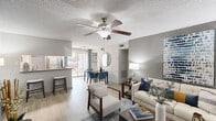 Located at 2020 Armstrong Mill Road in Lexington, Kentucky, this well-appointed 3-bedroom, 2-bathroom residence offers a thoughtfully designed single-floor layout. The open-concept living, dining, and kitchen area serves as the heart of the home, featuring light wood-style flooring, a ceiling fan with light fixture, and a large sliding glass door that fills the space with natural light. The kitchen is equipped with stainless steel appliances, granite-style countertops, a breakfast bar with seating, and ample cabinetry. The dining area flows seamlessly between the kitchen and living room, which offers a neutral color palette with an accent wall and generous room for seating. The three bedrooms are carpeted and each includes a ceiling fan and closet with hanging storage. The primary bedroom is a comfortable retreat with windows allowing in natural light. Both bathrooms feature dark-framed vanity mirrors, granite-style countertops with undermount sinks, and dark cabinetry. A dedicated laundry room with side-by-side washer and dryer connections and shelving adds everyday convenience. Hallways connect the rooms efficiently throughout the well-organized floor plan.