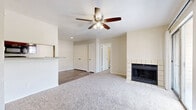 Located at 2809 W William Cannon Dr in Austin, TX, this two-bedroom, two-bathroom unit offers a well-organized single-level layout designed for comfortable everyday living. The living room serves as the heart of the home, featuring plush carpeting, a ceiling fan, a tiled wood-burning fireplace, and sliding glass doors that open to a private balcony with views of the tree-lined community grounds. The kitchen is efficiently designed with rich dark-stained cabinetry, light countertops, wood-look vinyl flooring, and a full suite of black appliances including a range, microwave, and dishwasher. The primary bedroom is a comfortable retreat, carpeted with a ceiling fan and a window that lets in natural light and outdoor views. The second bedroom is equally well-appointed with plush carpeting and neutral walls. Each bathroom features a tub-shower combination, a single-sink vanity with dark wood cabinetry, and wood-look flooring. The primary bath is distinguished by large-format stone-look tile surrounding the tub, while the secondary bath features clean white subway tile. Ceiling fans are present throughout, contributing to year-round comfort in this practical Austin residence.