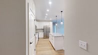 Located at 4775 Dublin Rd in Columbus, Ohio, this thoughtfully designed single-story, 2-bedroom, 1-bathroom home offers a clean, contemporary aesthetic throughout. The open-concept kitchen and living area serves as the heart of the home, featuring warm hardwood-style flooring, neutral toned walls, and abundant natural light from a large front-facing window. The kitchen is a standout, showcasing crisp white shaker cabinetry, a herringbone tile backsplash, granite countertops, a central island with pendant lighting, and a full suite of stainless steel appliances. The living area flows naturally from the kitchen, creating a welcoming, functional shared space. Both bedrooms are carpeted and finished with neutral walls and white trim, offering a calm and restful atmosphere. The primary bedroom is a comfortable size with access to the full bathroom, which features hardwood-style flooring, a granite-topped vanity with white cabinetry, black hardware accents, a walk-in shower, and direct access to a closet with wire shelving. A dedicated laundry room houses a full-size Samsung washer and dryer set. The home presents a well-appointed, move-in-ready layout ideal for modern living.