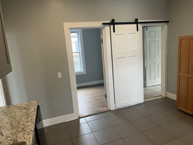 One bedroom directly off kitchen. Along with a hallway that leads to a bathroom, sunroom and bedroom - 94 Woodford St