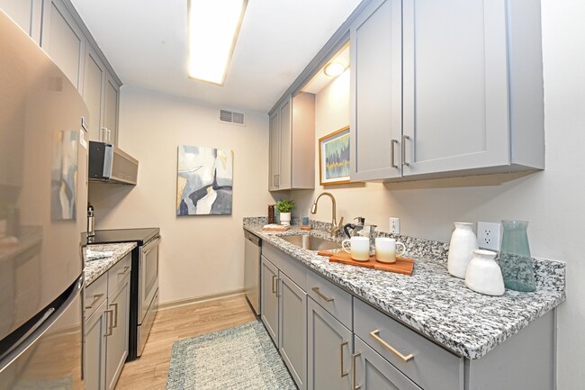 Kitchen with granite counters, stainless appliances, and modern cabinetry - Kinley at the Park