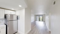 Located on the third floor at 6975 W 16th Ave in Hialeah, Florida, this thoughtfully updated unit offers a clean, modern aesthetic throughout. Light wood-style flooring flows seamlessly across every room, creating a bright and cohesive feel. The open living area extends toward a glass sliding door that opens onto a private balcony, allowing natural light to flood the space and providing views of the surrounding neighborhood's greenery.

The kitchen is well-appointed with white shaker cabinetry, white quartz countertops, stainless steel appliances including a refrigerator, range, microwave, and dishwasher, as well as recessed lighting and a window for added ventilation. The layout connects efficiently to the living area.

The bedrooms are generously proportioned with crisp white walls, light flooring, and windows that invite natural light. Closet space is provided in the bedrooms, complementing the functional layout.

Two bathrooms serve the unit. The primary bathroom features a floating vanity with a white countertop, large mirror, glass-enclosed shower, and wood-style flooring. The second bathroom includes a full tub-shower combination with large-format tile surround, a vanity, and matching finishes.

An in-unit washer and dryer area adds everyday convenience, rounding out this well-designed and move-in-ready Hialeah residence.