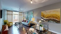 Located at 3350 Toledo Terrace in Hyattsville, MD, this single-floor apartment offers a well-designed, open-concept layout that seamlessly connects the kitchen, dining, and living areas. Rich hardwood-style flooring flows throughout the main living spaces, anchoring a bright and contemporary interior with neutral gray walls accented by bold teal and yellow tones.

The kitchen is a standout feature, equipped with dark espresso cabinetry, stainless steel appliances, granite countertops, and a large center island with bar seating. Pendant lighting overhead enhances both function and style. The adjacent living and dining area is filled with natural light from floor-to-ceiling sliding glass doors that open to a private outdoor balcony, complemented by a ceiling fan overhead.

The bedroom is generously sized with plush carpeting, a ceiling fan, large windows, and direct balcony access, creating a bright and airy retreat. A spacious walk-in closet with wire shelving and hanging rods provides ample storage. The bathroom features tile flooring, dark cabinetry with granite countertops, an undermount sink, and a soaking tub with a shower combination. Every detail reflects a modern, comfortable living environment suited for everyday life.