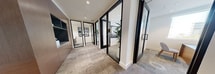 This contemporary office space, located at 3585 Aero Ct, San Diego CA 92123, offers 1,630 square feet of meticulously designed workspace. The single-story layout showcases a harmonious blend of open-concept areas and private offices. Upon entry, visitors are greeted by a striking two-story atrium with a glass balustrade, creating a sense of spaciousness and connectivity between levels.

The space features high ceilings with recessed lighting and elegant cove details, enhancing the overall ambiance. Large windows throughout provide ample natural light and offer views of the surrounding area, including glimpses of palm trees. The flooring consists of neutral-toned carpeting, contributing to the professional yet inviting atmosphere.

Private offices are equipped with sleek wooden desks, ergonomic chairs, and large windows, offering both functionality and comfort. A standout feature is the built-in workstation area, boasting three individual spaces with wooden partitions, integrated shelving, and modern seating. This area is perfect for focused work or small collaborative sessions.

The open-concept layout encourages collaboration and flexibility, with various seating arrangements and meeting areas. Thoughtful design elements, such as a striking wall art piece and contemporary pendant lighting, add visual interest and personality to the space. Overall, this office environment strikes an ideal balance between professionalism, comfort, and modern design aesthetics.