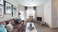 This single-story residence at 7596 Pitcher Point in Fountain, Colorado, presents a well-organized open-concept layout that connects the primary living areas seamlessly. The kitchen is equipped with warm honey-toned cabinetry, light countertops, wood-look flooring, and black appliances including a refrigerator, electric range, and over-the-range microwave. A peninsula counter provides additional workspace and a natural transition into the adjacent dining and living areas.

The living room is bright and welcoming, featuring wood-look flooring, large windows with access to an exterior door, and a corner fireplace that anchors the space. Neutral walls throughout the home create a versatile backdrop suitable for a variety of décor styles.

The bedrooms are carpeted and feature windows that allow natural light to filter in, contributing to a comfortable and restful atmosphere. A double door closet is visible off the kitchen area, offering practical storage.

The bathroom includes a full soaking tub and shower combination with white tile surround, complemented by wood-look flooring and clean, simple finishes. Overall, the home maintains a cohesive neutral palette with functional design elements throughout.