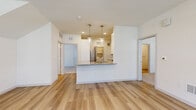 This single-floor, 2-bedroom, 2-bathroom residence offers a thoughtfully designed open-concept layout with modern finishes throughout. The living area is bright and welcoming, featuring light wood-style flooring, a ceiling fan, and multiple windows with blinds that allow ample natural light and views of the surrounding exterior. The kitchen flows seamlessly into the living space and includes a peninsula with granite countertops, pendant lighting, white cabinetry, a stainless steel refrigerator, and direct access to a dedicated in-unit laundry room equipped with a full-size washer and dryer. Both bedrooms are carpeted and include ceiling fans and windows with outdoor views. The primary bedroom offers a comfortable footprint with its own closet, while the second bedroom provides similar comfort and access to storage. Each bathroom is finished with granite-topped white vanities and marble-style tile surrounds in the tub and shower areas, complemented by brushed gold fixtures and wood-style flooring. A dedicated laundry room with overhead shelving adds everyday convenience. The clean, neutral palette and consistent use of quality materials create a cohesive and functional living environment throughout the entire space.