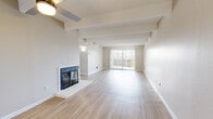 Located at 10050 E Harvard Ave in Denver, Colorado, this 2-bedroom, 3-bathroom residence offers a well-designed single-floor layout with a warm, neutral aesthetic throughout. Light wood-style flooring runs continuously across the space, complemented by textured ceilings and distinctive exposed beam detailing that adds architectural character to each room.

The expansive living room serves as the heart of the home, anchored by a white brick wood-burning fireplace and a ceiling fan overhead. Sliding glass doors flood the space with natural light and open to a private balcony, extending the living area outdoors.

The galley-style kitchen is efficiently designed with rich dark cabinetry, light quartz countertops, a subtle tile backsplash, stainless steel appliances including a range, microwave, and refrigerator, and track lighting above. It flows naturally into the adjacent dining area.

The spacious primary bedroom features a generous closet with sliding doors, and its en-suite bathroom includes a soaking tub, a wide vanity with quartz counters, dark cabinetry, and ample mirror space. The second bedroom is bright and well-proportioned with a large closet and natural window light. Additional bathrooms include a walk-in glass-door shower, continuing the home's clean, modern finishes throughout.