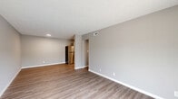 Located at 320 Brown St in West Lafayette, Indiana, this single-floor unit offers four bedrooms, one bathroom, and a well-designed layout that maximizes functionality. Luxury vinyl plank flooring runs throughout the entire space, providing a cohesive and easy-to-maintain surface. Neutral gray walls and white trim create a clean, modern aesthetic in every room.

The combined kitchen and living area serves as the heart of the unit. The kitchen is outfitted with white shaker-style cabinetry, white countertops, a stainless steel sink, and a full suite of stainless steel appliances including a refrigerator, range, microwave, and dishwasher. The open living room receives natural light and features sliding glass doors that open to a private balcony with views of the surrounding area.

The four bedrooms are well-proportioned, with the primary bedroom offering generous square footage and dedicated closet space with built-in wire shelving. Each bedroom features windows with blinds, allowing for ample natural light. A hallway connects the bedrooms to the shared full bathroom, which includes a tub-shower combination with white tile surround and a decorative mosaic accent strip. A dedicated laundry room houses a full-size Samsung front-loading washer and dryer, adding significant everyday convenience to this well-appointed unit.