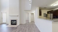 This 1-bedroom, 1-bathroom apartment in Peabody, MA spans 1,100 square feet across two floors, offering a well-designed layout with a variety of functional spaces. The main floor (700 sq ft) features an open-concept kitchen and living room area with soaring ceilings and large windows that invite abundant natural light. The kitchen is appointed with rich dark cabinetry, granite countertops, a mosaic tile backsplash, and a full suite of stainless steel appliances including a gas range, microwave, and refrigerator. The living room showcases a tile-surround fireplace with a white mantel and luxury vinyl plank flooring throughout. The upper floor (410 sq ft) hosts the carpeted bedroom (130 sq ft), which features a ceiling fan, a bright window, and direct access to a spacious walk-in closet equipped with wire shelving systems. The full bathroom includes a tiled tub/shower combo, a toilet, tile flooring, and an oversized white storage cabinet. A dedicated laundry area with a full-size stainless steel washer and dryer completes the upper level, adding everyday convenience to this thoughtfully appointed home.