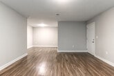 Located at 5100 Welcome All Rd SW in South Fulton, Georgia, this single-floor unit offers a well-designed layout with a variety of modern finishes throughout. The galley-style kitchen is a standout feature, showcasing dark espresso cabinetry, granite countertops, a stainless steel sink, and black appliances including a refrigerator, electric range, and over-the-range microwave. Rich hardwood-style flooring runs through the kitchen and main living areas, adding warmth and visual continuity. The living spaces are open and versatile, with neutral-toned walls, clean white baseboards, and ample room to configure furnishings comfortably. Natural light flows in through multiple windows fitted with blinds, offering views of the surrounding greenery. The bedrooms are carpeted and include ceiling fans with lighting, creating a comfortable and functional environment. Each room benefits from windows that bring in outdoor light and lend a connection to the natural surroundings. The bathrooms are clean and practical — one features a full soaking tub with a shower, while another includes a floating dark-wood vanity with a white basin sink and well-lit mirror. Throughout the unit, the design balances contemporary updates with functional simplicity, making for a cohesive and move-in ready space.