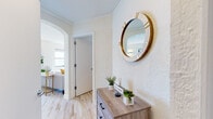 Located at 1400 N Lake Shore Drive in Chicago's prestigious Gold Coast neighborhood, this single-floor unit offers a thoughtfully designed layout with a warm, modern aesthetic. The entryway sets an inviting tone, featuring light hardwood flooring, textured white walls, a decorative arched doorway, and a welcoming console area with a round statement mirror. The bright living room is characterized by clean white walls with crown molding, natural light from oversized windows, and hardwood floors, creating an airy and comfortable gathering space. The bedroom is a serene retreat with a wall-mounted television and a large window that allows natural light to filter in. The kitchen is efficiently designed with white shaker-style cabinetry, light quartz countertops, a textured tile backsplash, stainless steel appliances including a gas range, microwave, refrigerator, and dishwasher, and slate-toned tile flooring. The bathroom features marble-patterned tile on both the floors and walls, a soaking tub with shower, a pedestal sink, and a medicine cabinet mirror, delivering a clean and classic finish. Throughout the unit, a cohesive palette of whites and light neutrals, combined with hardwood flooring in the main living areas, contributes to a bright and polished overall ambiance.