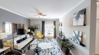 This thoughtfully designed single-floor residence combines modern aesthetics with comfortable, functional living. The living room serves as the heart of the home, showcasing crown molding, hardwood flooring, and a ceiling fan overhead. Natural light pours in through French doors dressed with elegant gray drapes, while the open layout accommodates generous seating and stylish décor accents.

The kitchen is both practical and refined, featuring warm wood cabinetry, gleaming granite countertops, a double stainless steel sink, tile flooring, and stainless steel appliances. Pendant lighting adds a polished touch, and the space flows seamlessly into a dining area adorned with crown molding and a statement pendant light fixture.

The bedroom is a serene retreat, highlighted by a dramatic arched accent wall that frames a dedicated sitting nook. Plush carpeting, a ceiling fan, and ample natural light from window treatments contribute to the room's calm ambiance.

Both bathrooms are finished consistently with granite-topped wood vanities, tile flooring, and neutral wall tones. One features a shower-tub combination, while the other is configured as a well-organized full bath. Throughout the residence, a cohesive gray and neutral palette ties each space together, creating a harmonious and contemporary living environment.