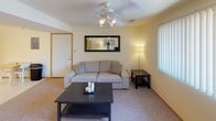 Located at 401 Russell Rd in DeKalb, Illinois, this single-floor unit offers a practical and comfortable layout designed for everyday living. The living room serves as a welcoming central space, featuring soft carpeted flooring, a ceiling fan with integrated lighting, a decorative wall mirror, and a window with vertical blinds that allows natural light to filter in. The kitchen is efficiently arranged in an L-shaped layout, outfitted with white cabinetry accented by wood trim, a double-basin sink, electric range, dishwasher, and recessed lighting overhead. The unit includes two bedrooms, both carpeted and naturally lit by windows with blinds. One bedroom features dual closet doors and ample space for furnishings, while the second offers a cozy, well-proportioned layout with room for a dresser and nightstand. Two bathrooms serve the unit: a full bath with a granite-style vanity countertop, a tub-shower combo with a curtain, and tile flooring; and a secondary bathroom conveniently combined with an in-unit laundry area equipped with a full-size washer and dryer and overhead cabinetry for storage. Throughout the unit, neutral tones and consistent finishes create a cohesive, functional living environment.