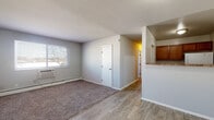 Located at 4233 Allendorf Dr in Cincinnati, Ohio, this single-floor unit offers a practical and well-organized layout with a clean, neutral color palette throughout. The main living area features a combination of wood-style vinyl plank flooring and plush carpet, creating a comfortable transition between spaces. A front entry door with gold hardware opens directly into this open area, which benefits from a large window that brings in natural light and views of the surrounding neighborhood. A wall-unit air conditioner and baseboard heating ensure year-round comfort.

The kitchen, visible from the living area via a pass-through opening, includes medium-toned wood cabinetry and a light stone-style countertop. The bedrooms are carpeted and each equipped with ceiling fans with integrated lighting, baseboard heating, and windows that allow for natural light. Closet access is provided in select bedrooms for added storage.

The bathroom is finished with classic white subway-style wall tile surrounding a full soaking tub and shower combination, complemented by rich wood-toned upper cabinetry for storage. Tile flooring completes the space. Throughout the unit, consistent gray-toned walls, white trim, and understated finishes contribute to a cohesive and move-in-ready atmosphere.